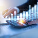 Persona che utilizza una calcolatrice con grafici finanziari in sovrimpressione