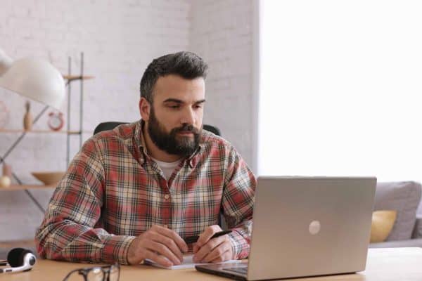 Uomo adulto che lavora al computer, riflettendo sul processo per effettuare il cambio di comparto nel Fondo Telemaco.