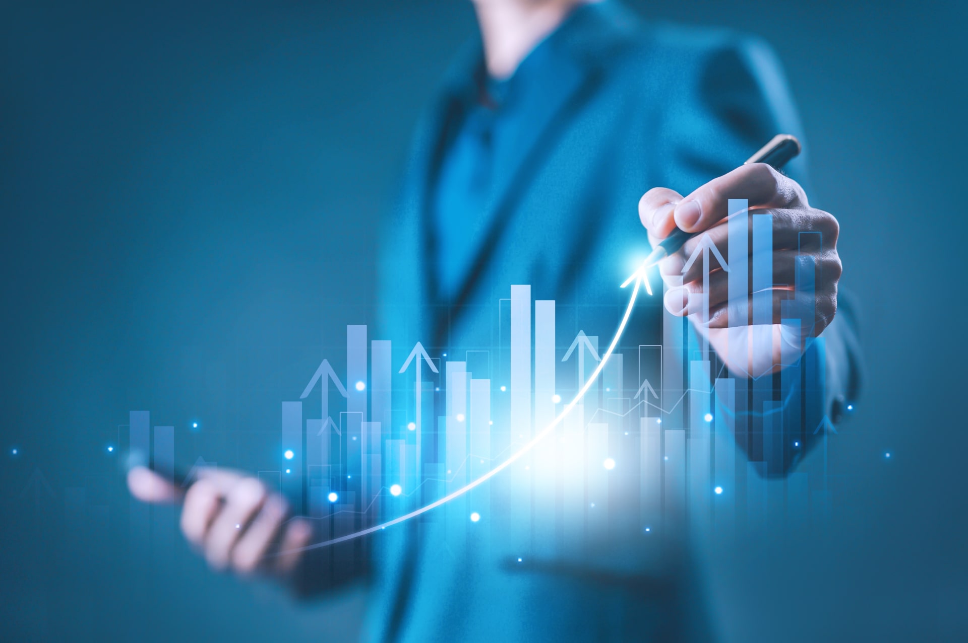 Un uomo traccia con una penna una linea ascendente su un grafico finanziario digitale e luminoso, simboleggiando la crescita economica e l'andamento positivo dei rendimenti.