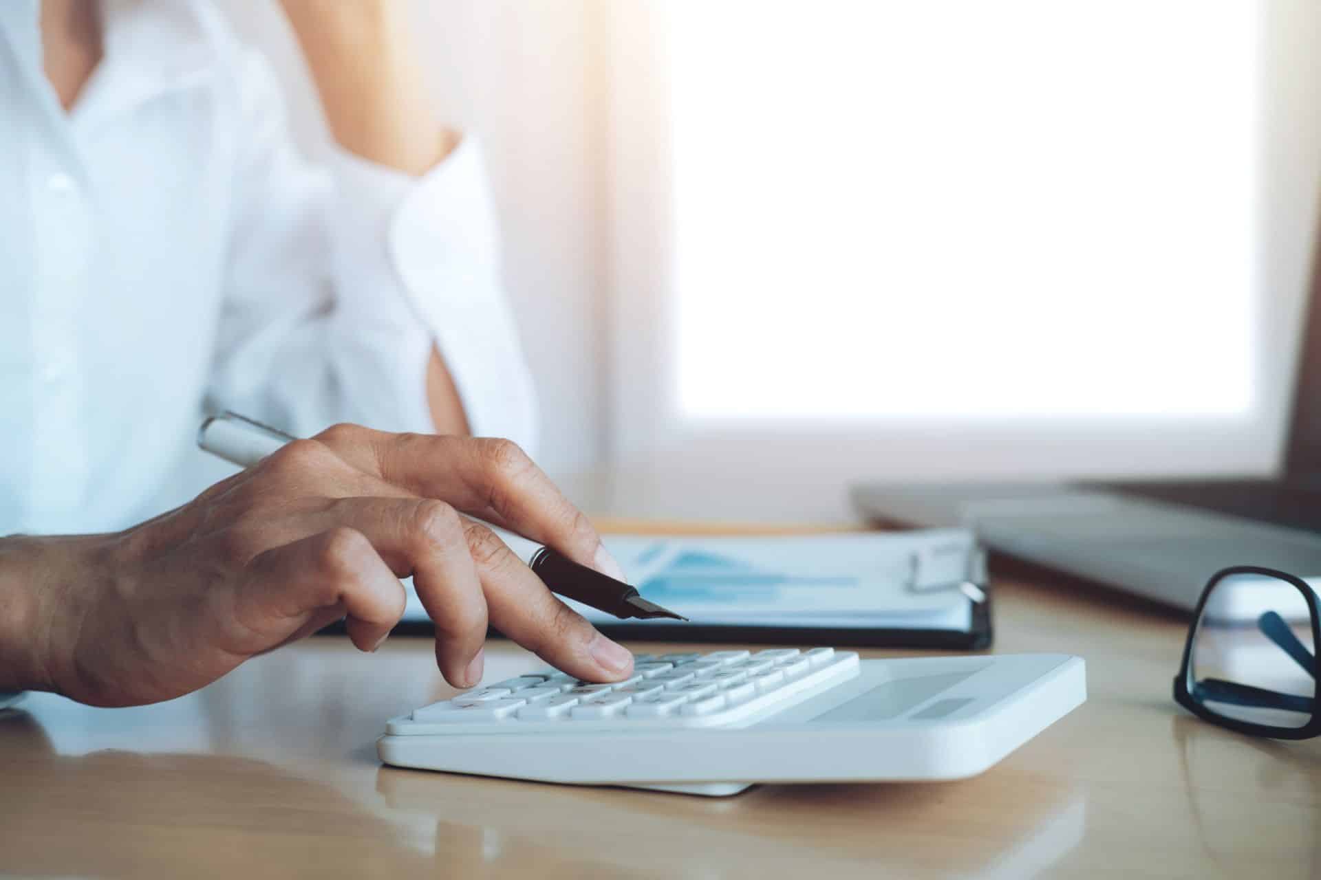 Persona alla scrivania usa una calcolatrice per stimare il risparmio fiscale legato al Fondo Telemaco