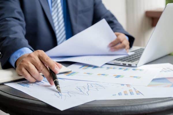 Professionista analizza grafici e documenti finanziari al computer, immagine sulla Relazione COVIP 2025