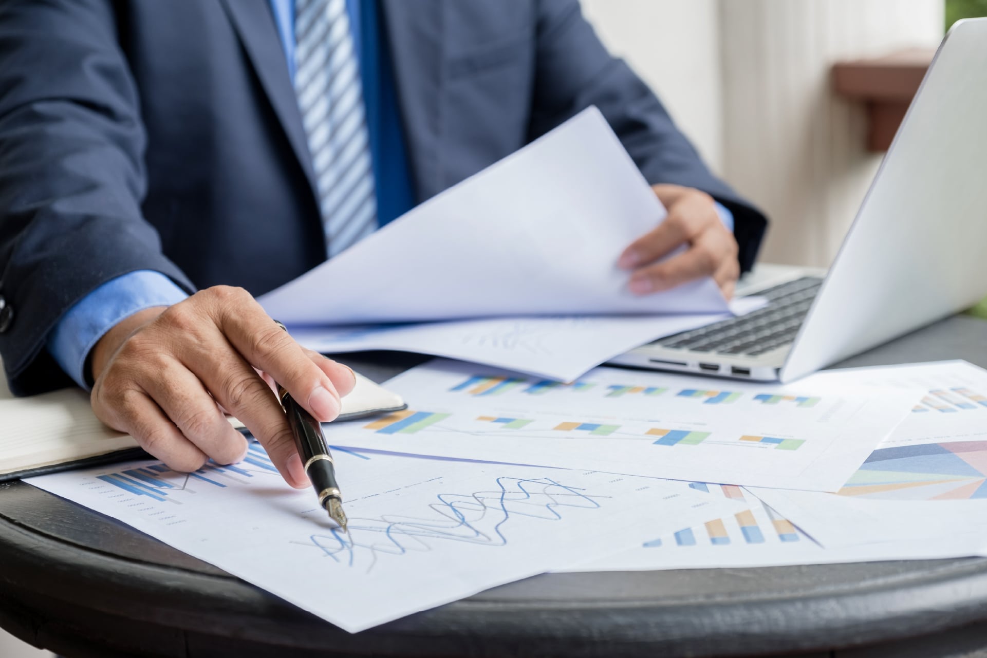 Professionista analizza grafici e documenti finanziari al computer, immagine sulla Relazione COVIP 2025